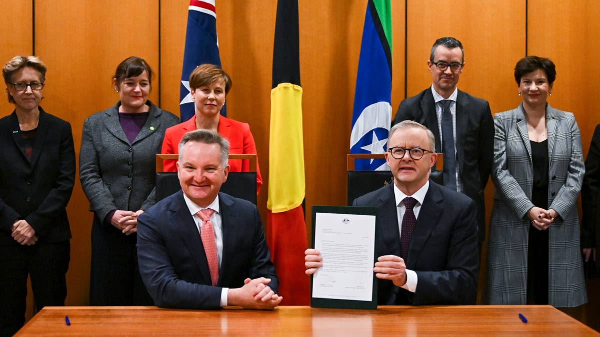 Prime Minister Anthony Albanese and Australian Minister for Climate Change Chris Bowen pose for photographs after signing the Nationally Determined Contribution to a 43% cut in emissions by 2030. (AAP Image/Lukas Coch)